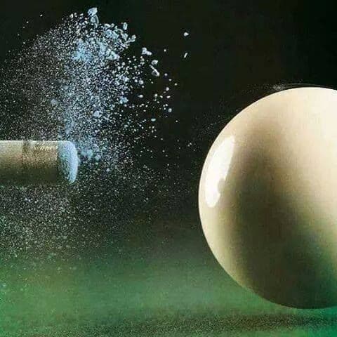 Cue tip striking the cue ball with chalk dust